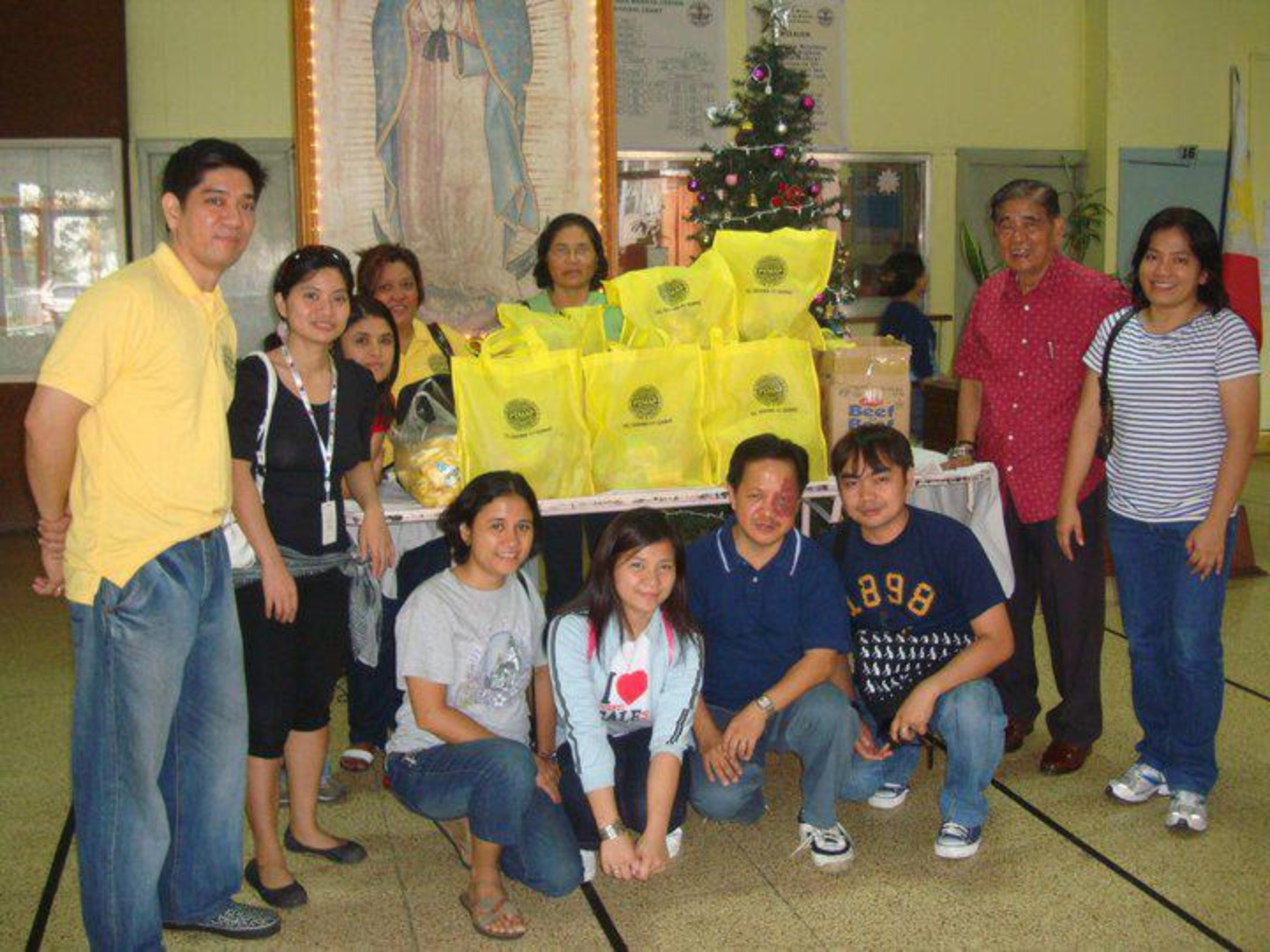 PEMAP members gathered around a table of packaged goods in PEMAP-themed bags